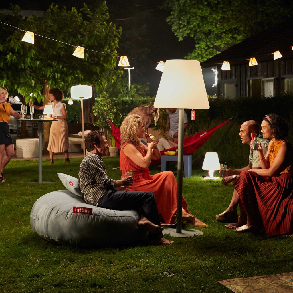 Die Gäste genießen die Gartenparty. Zwischen Fatboy Möbeln und Beleuchtung.