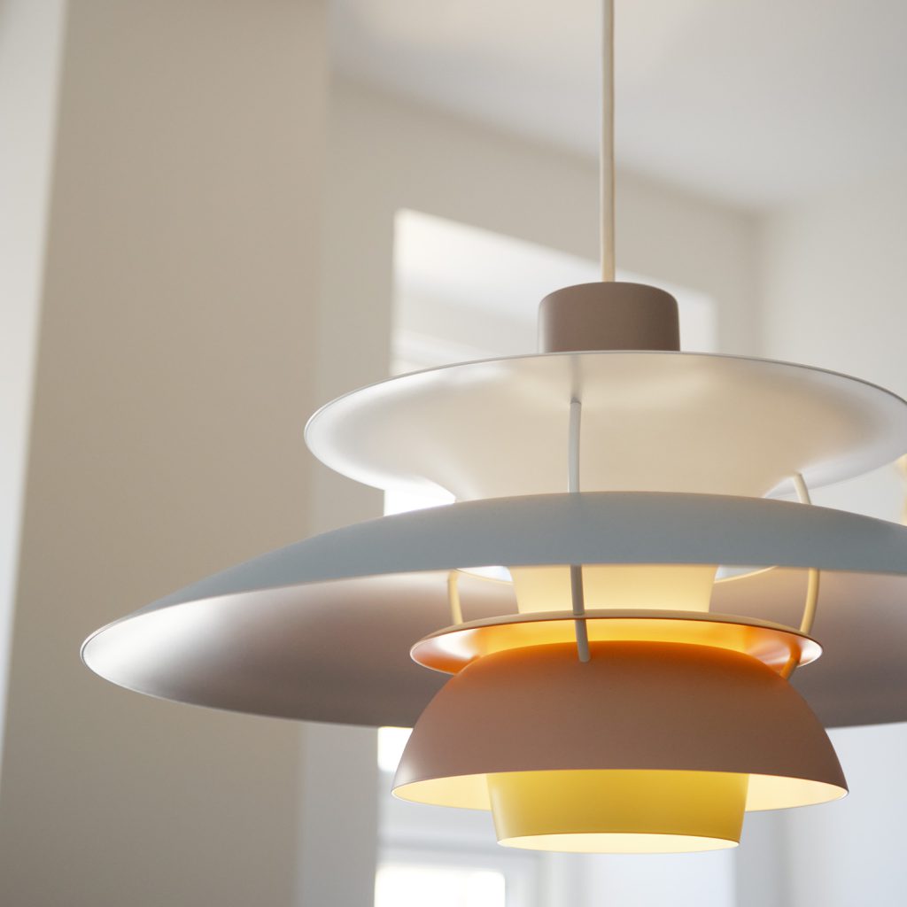 Drei Schirme in drei unterschiedlichen Pastellfarben spenden warmes, diffuses Licht. Hygge, die PH5 von Louis Poulsen. 