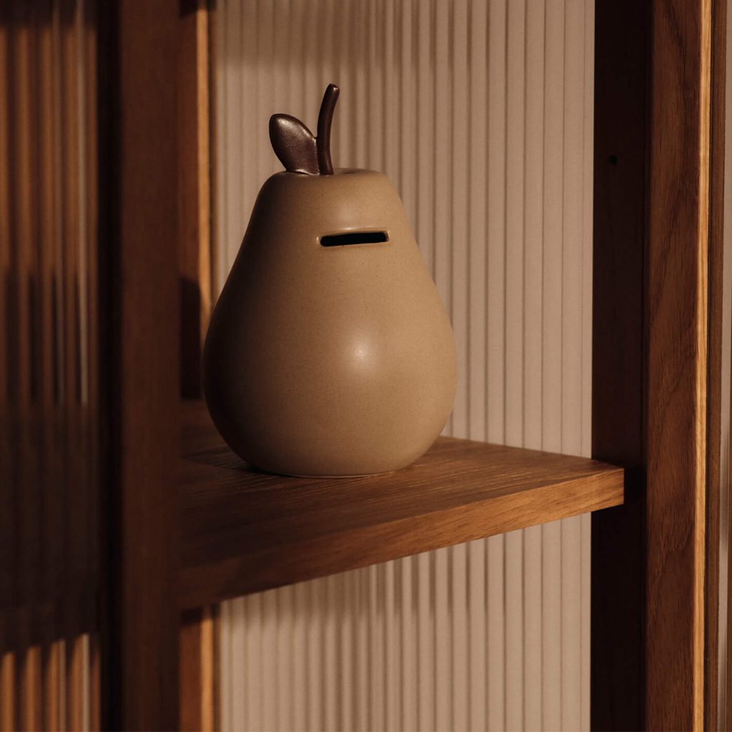 Fruchtige Herbstdekoration und Münzen-Sammler auf dem Regal: die Ferm Living Pear Spardose.